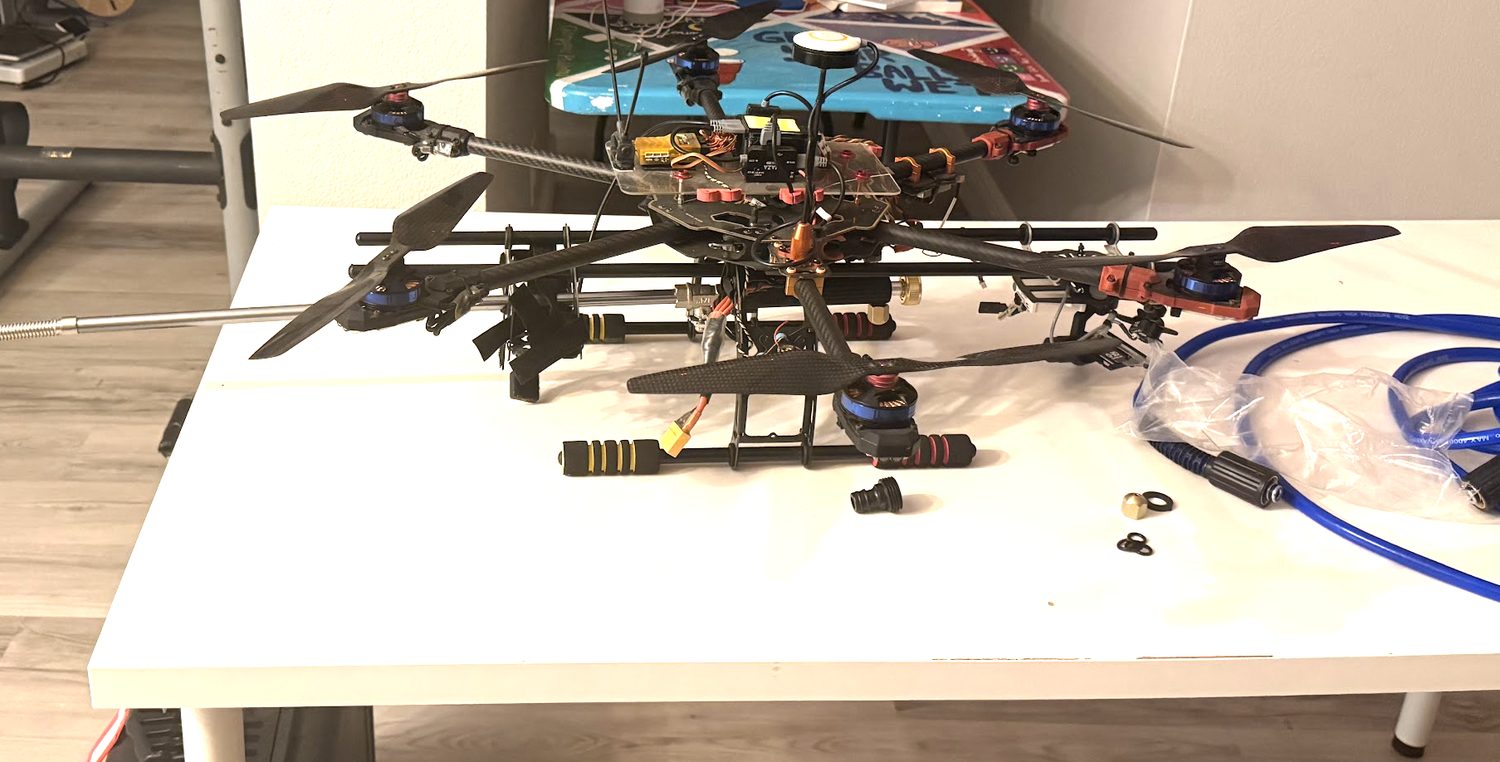 Window-washing drone prototype with pressure-wash hose and wand