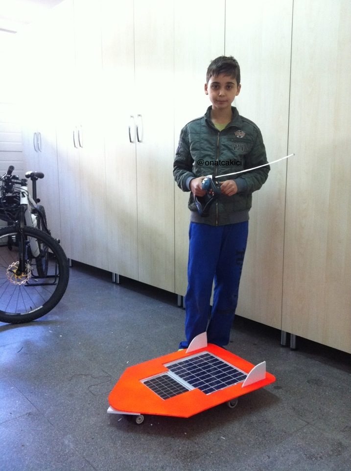 Onat Cakici at age 11 with the radio-controlled solar car he built