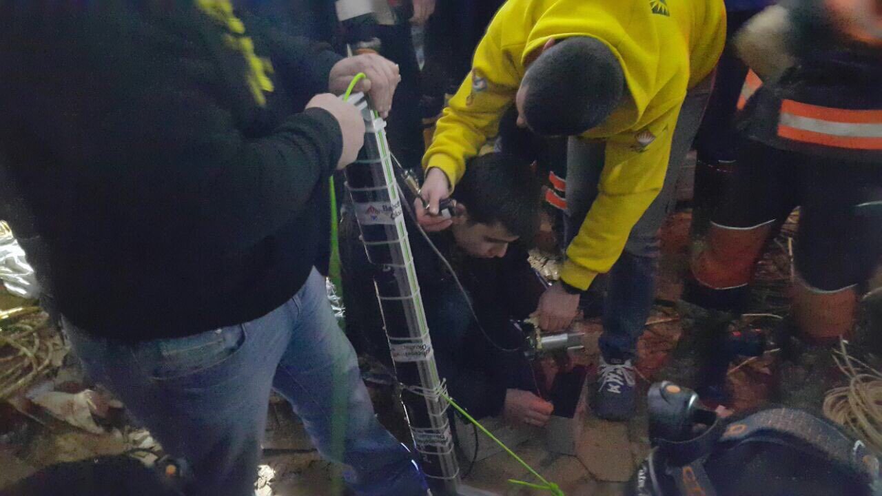 Onat Cakici connecting the battery to charge the pneumatic reservoir for the rescue arm's gripper during the well rescue